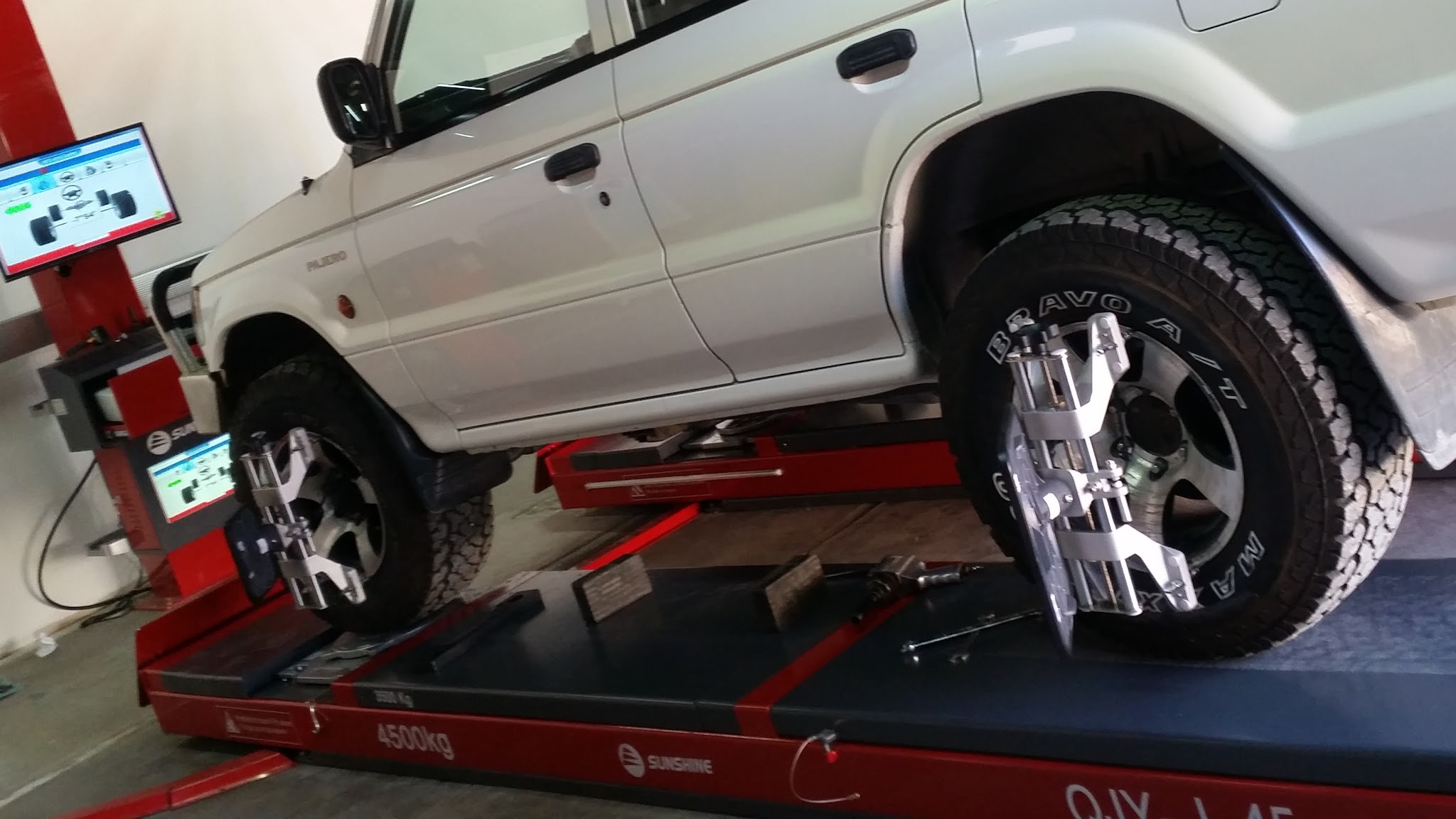 A four wheel drive up on the 3D wheel alignment hoist inside the Vick's Auto Service workshop