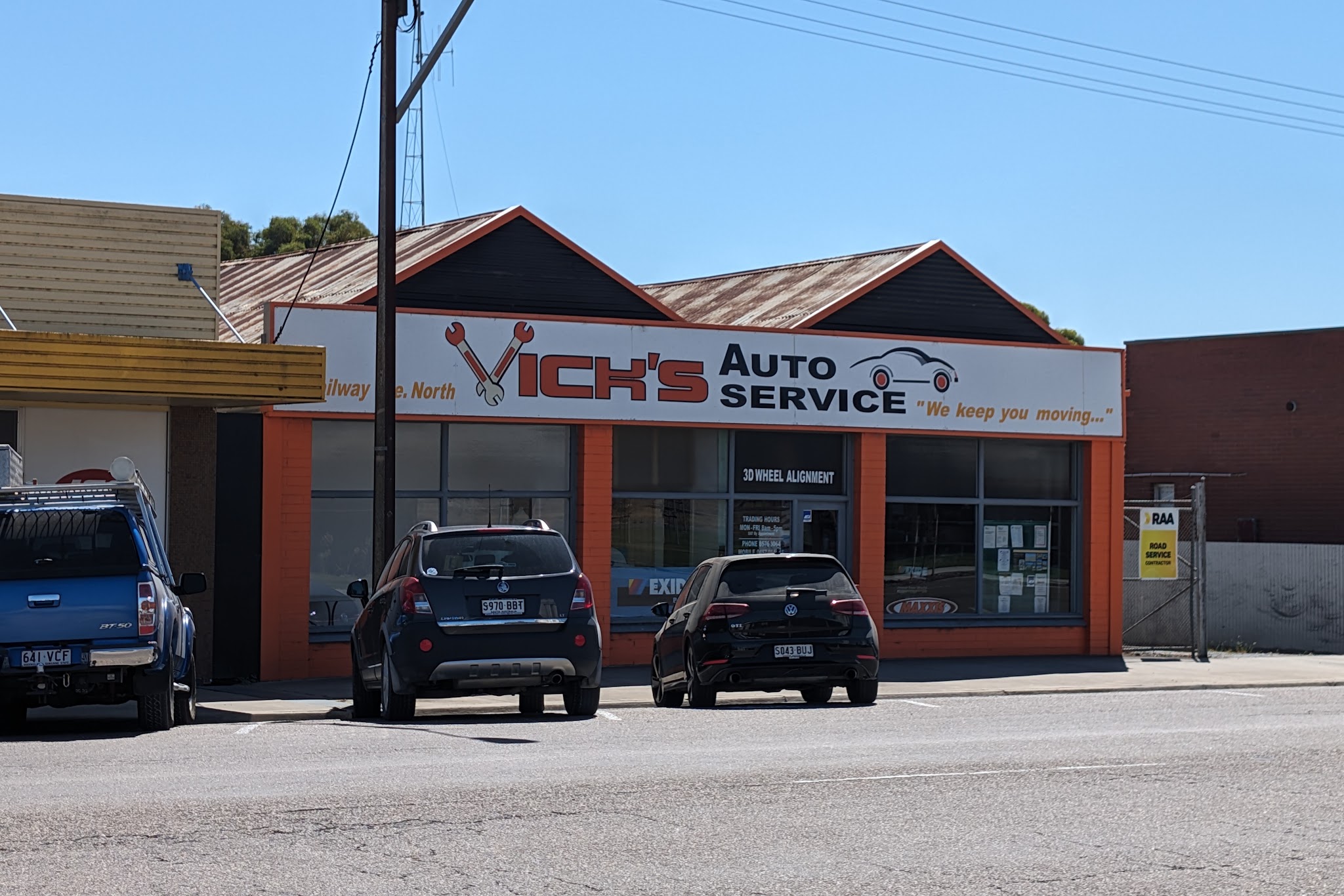 The workshop sign in full sun, reading Vick's Auto Service, We keep you moving